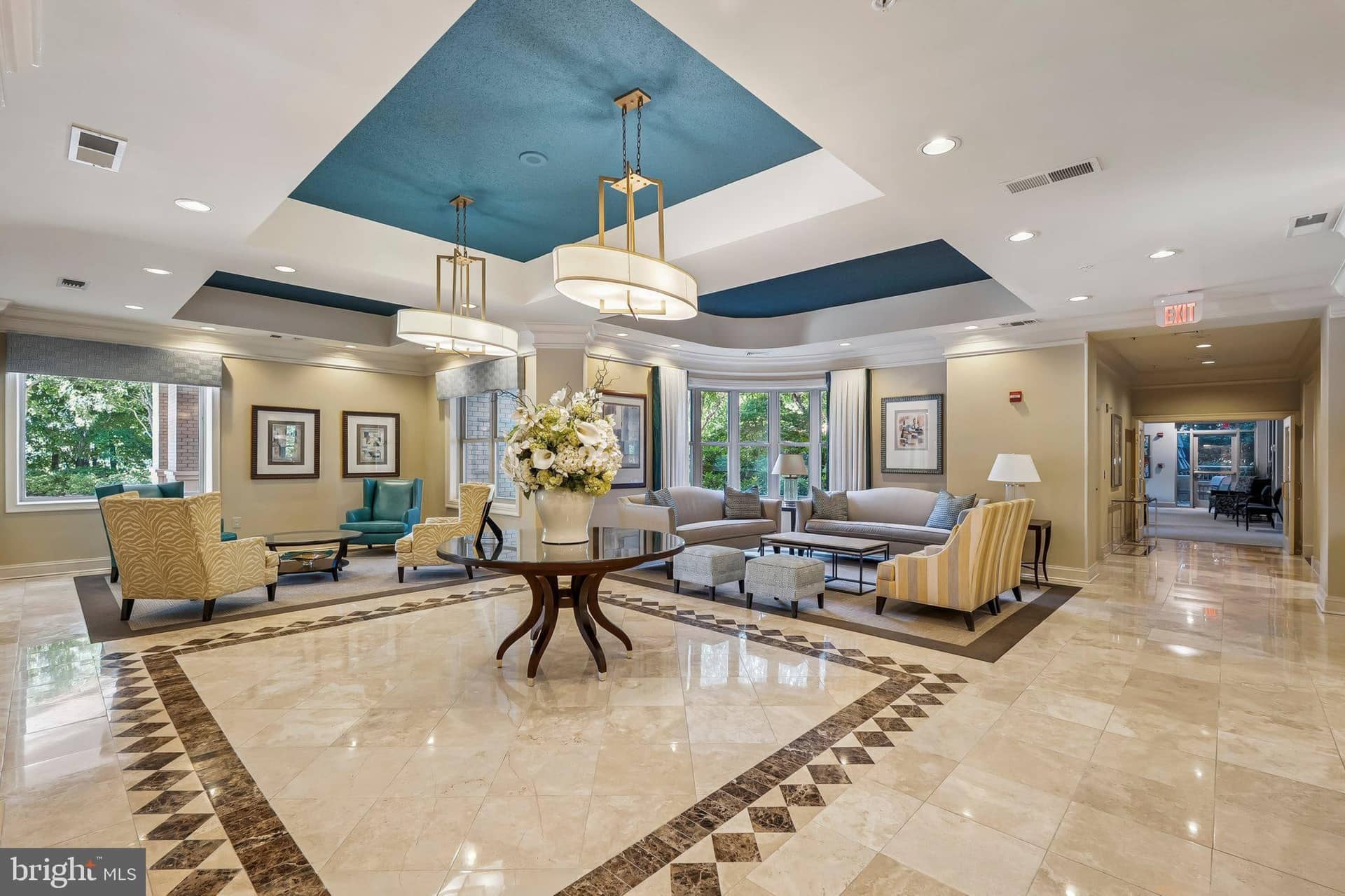 Stratford House lobby with polished stone floors, seating groups, and blue ceiling accents