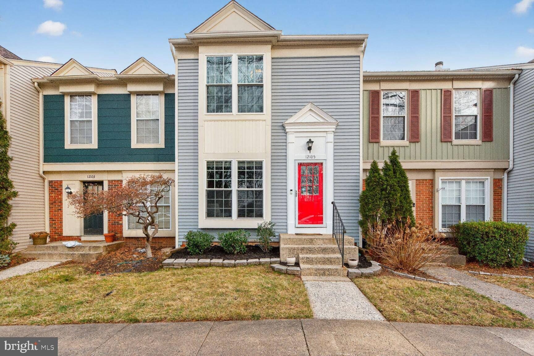 Front exterior of 12105 Wedgeway Place with gray siding and a red entry door
