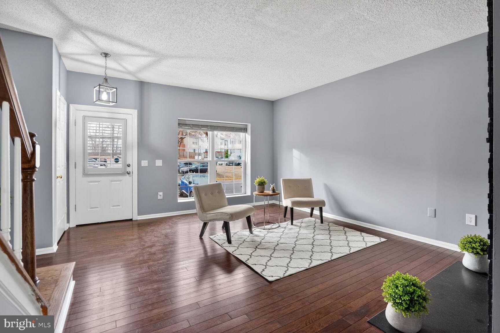 Main-level living area with hardwood floors and front-entry windows