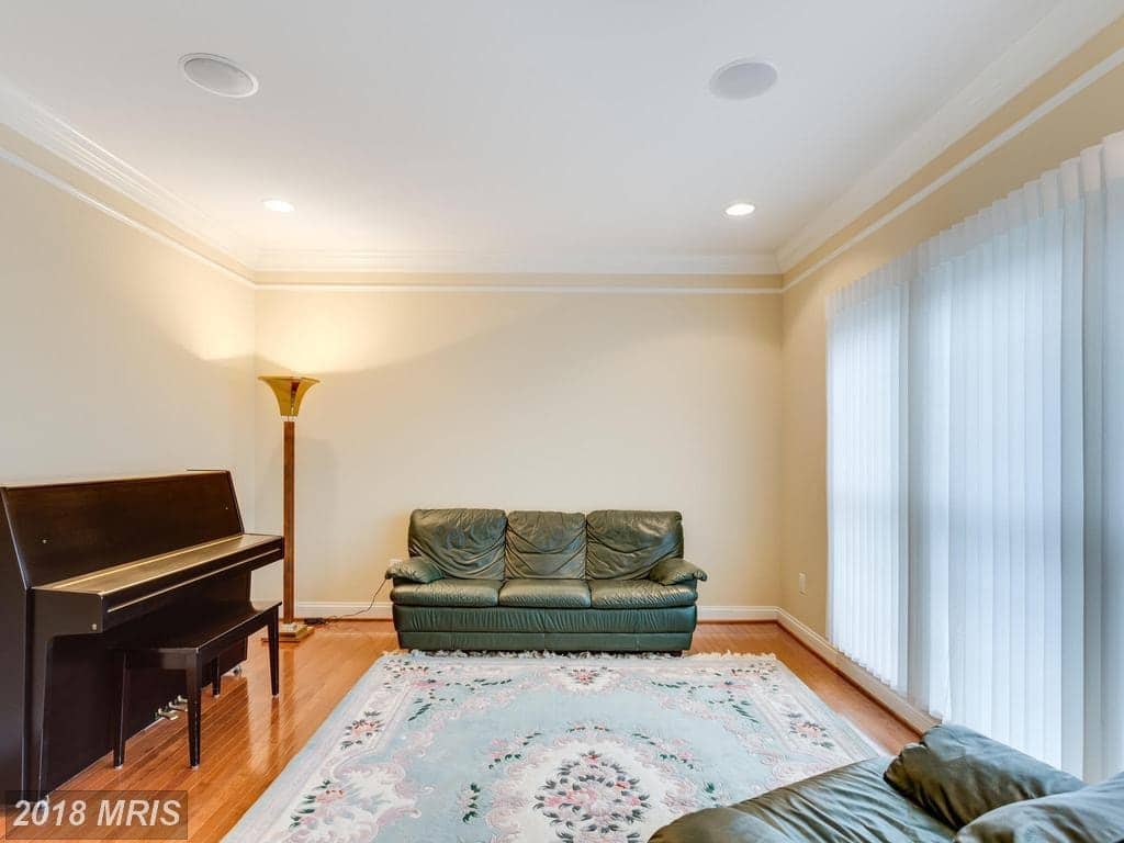 Formal living room at 12803 Holly Grove Court with crown molding, tall windows, a piano, and neutral seating