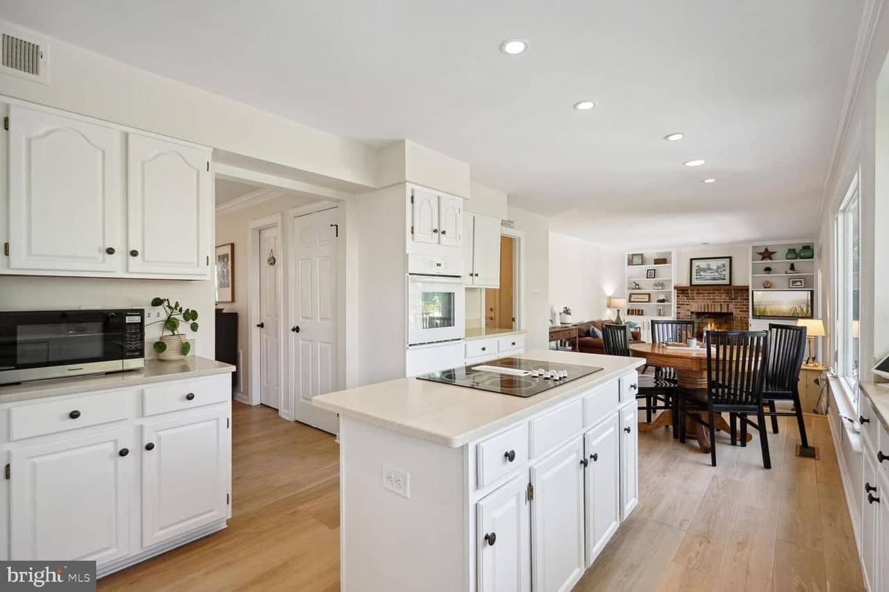 White kitchen with center island opening to the breakfast area and family room