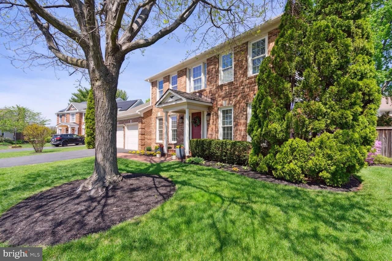 Angled front view of 13218 Topsfield Court showing mature landscaping and the covered entry