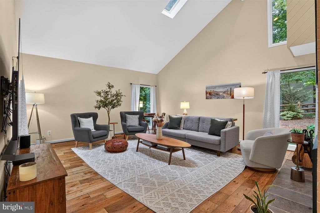 Vaulted living room with hardwood floors and tall windows at 2003 Upper Lake Drive
