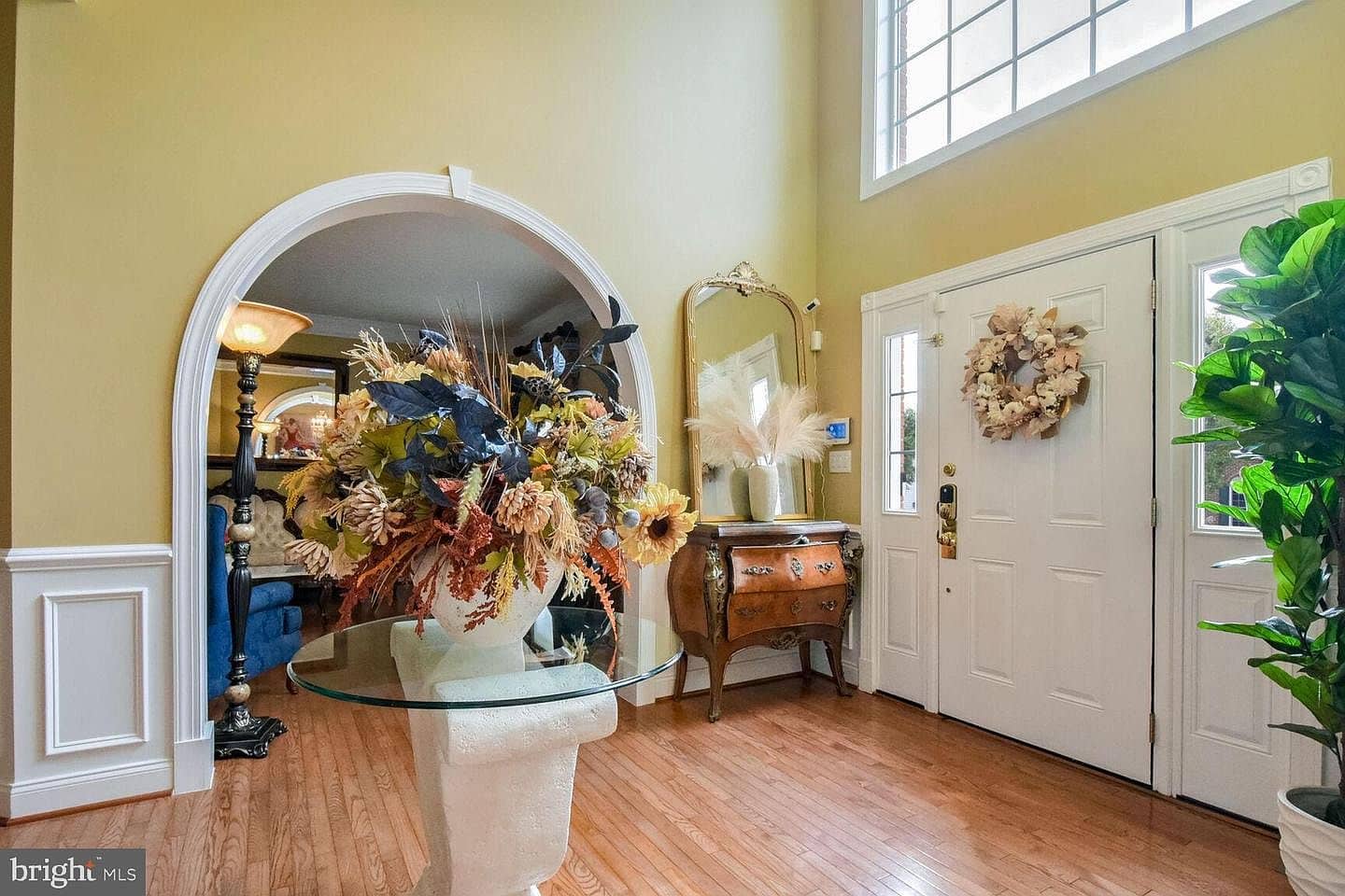 Two-story foyer with hardwood floors and arched opening