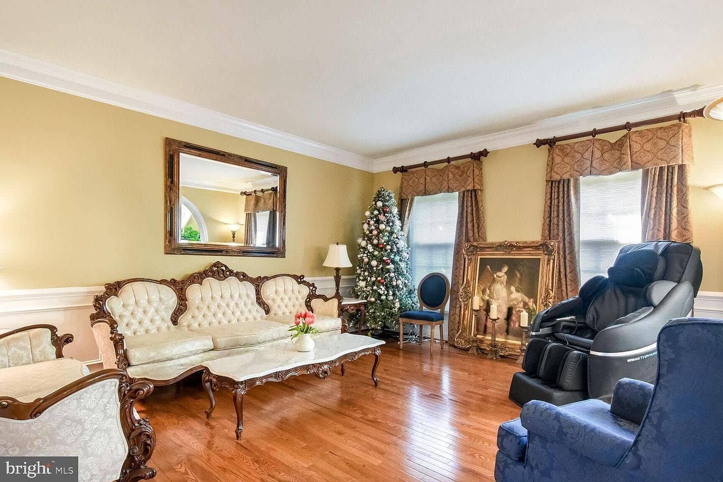 Formal living room with hardwood floors, crown molding, and chair rail