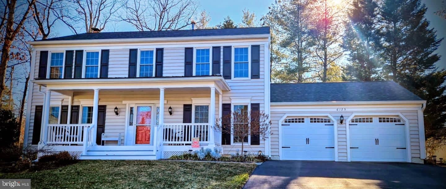 Front exterior of 6125 Sandstone Court with lawn, covered porch, and double garage