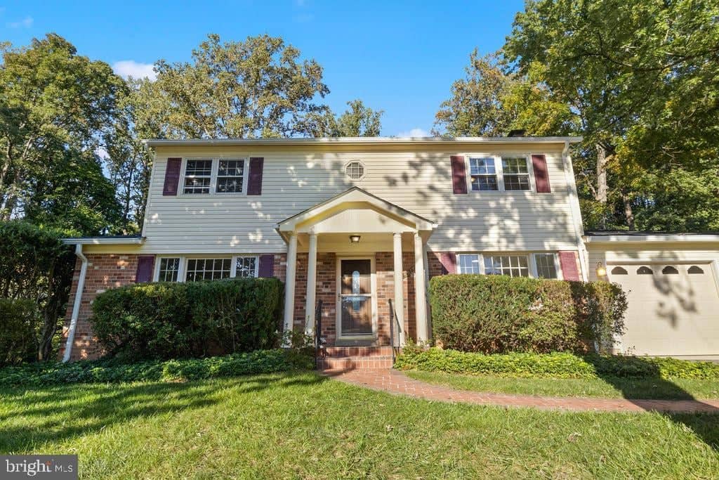 Front exterior with brick facade, covered entry, and attached garage at 6814 Grey Fox Drive