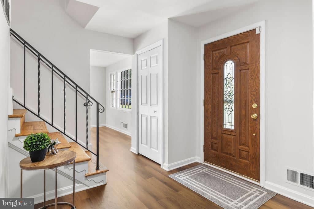 Entry foyer with decorative front door and hardwood staircase at 6814 Grey Fox Drive