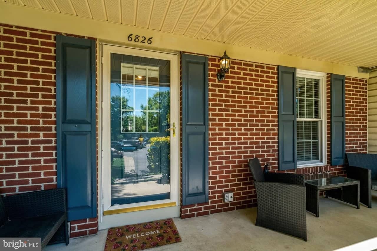 Covered front porch at 6826 Ericka Avenue with seating beside the entry door