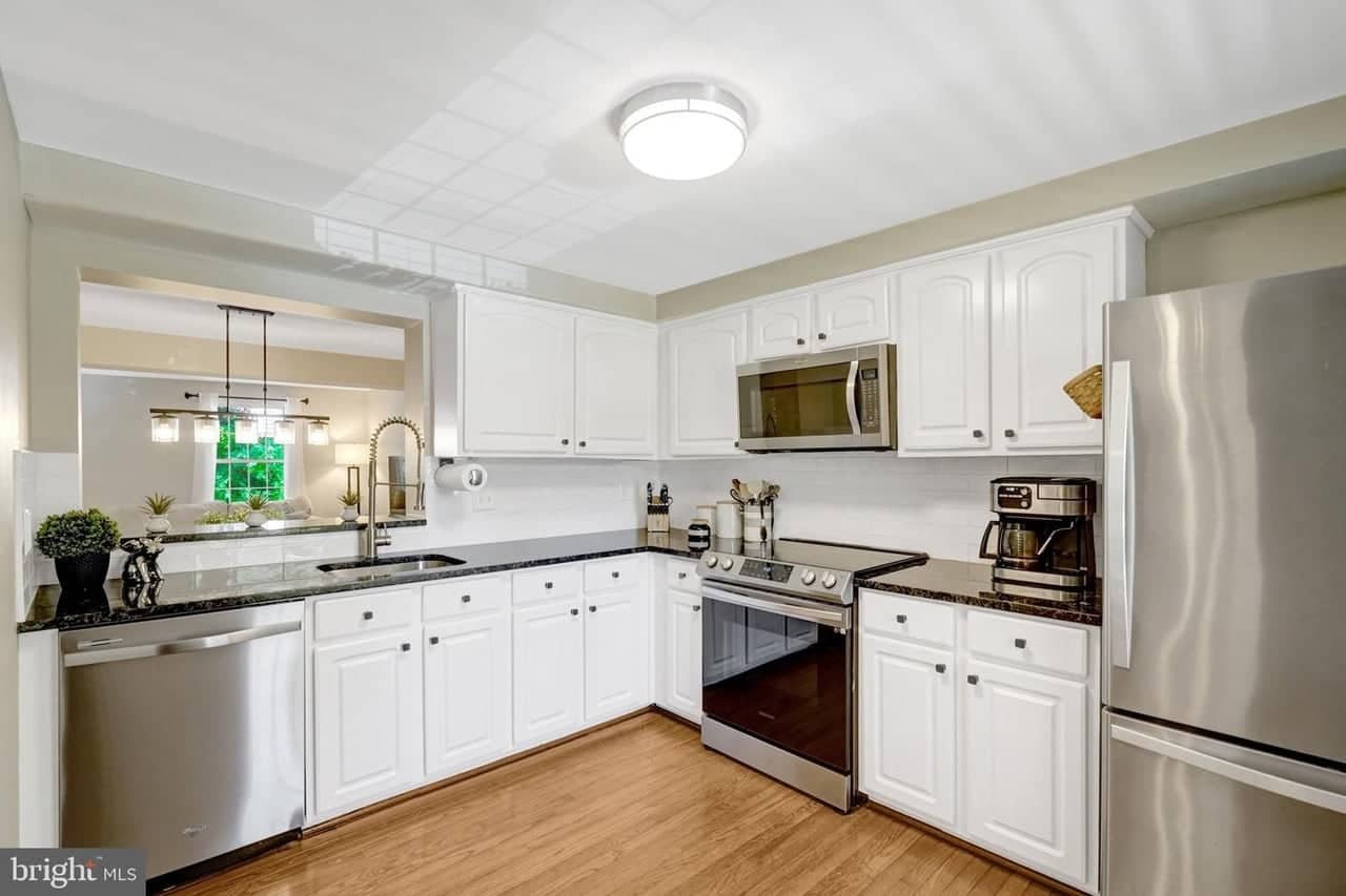 Kitchen with white cabinetry, granite counters, and stainless-steel appliances