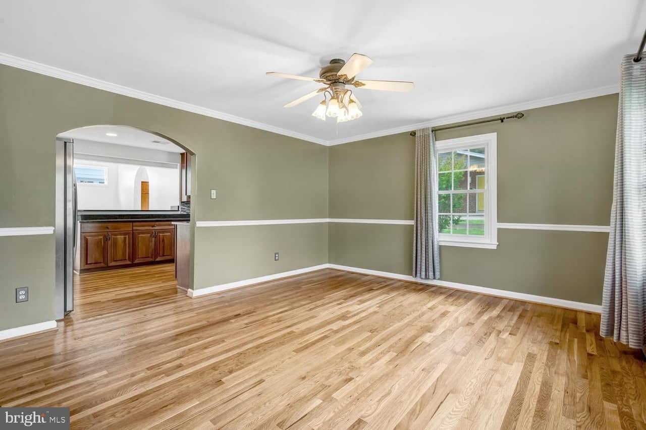 Dining room with refinished hardwood floors and an arched opening to the kitchen