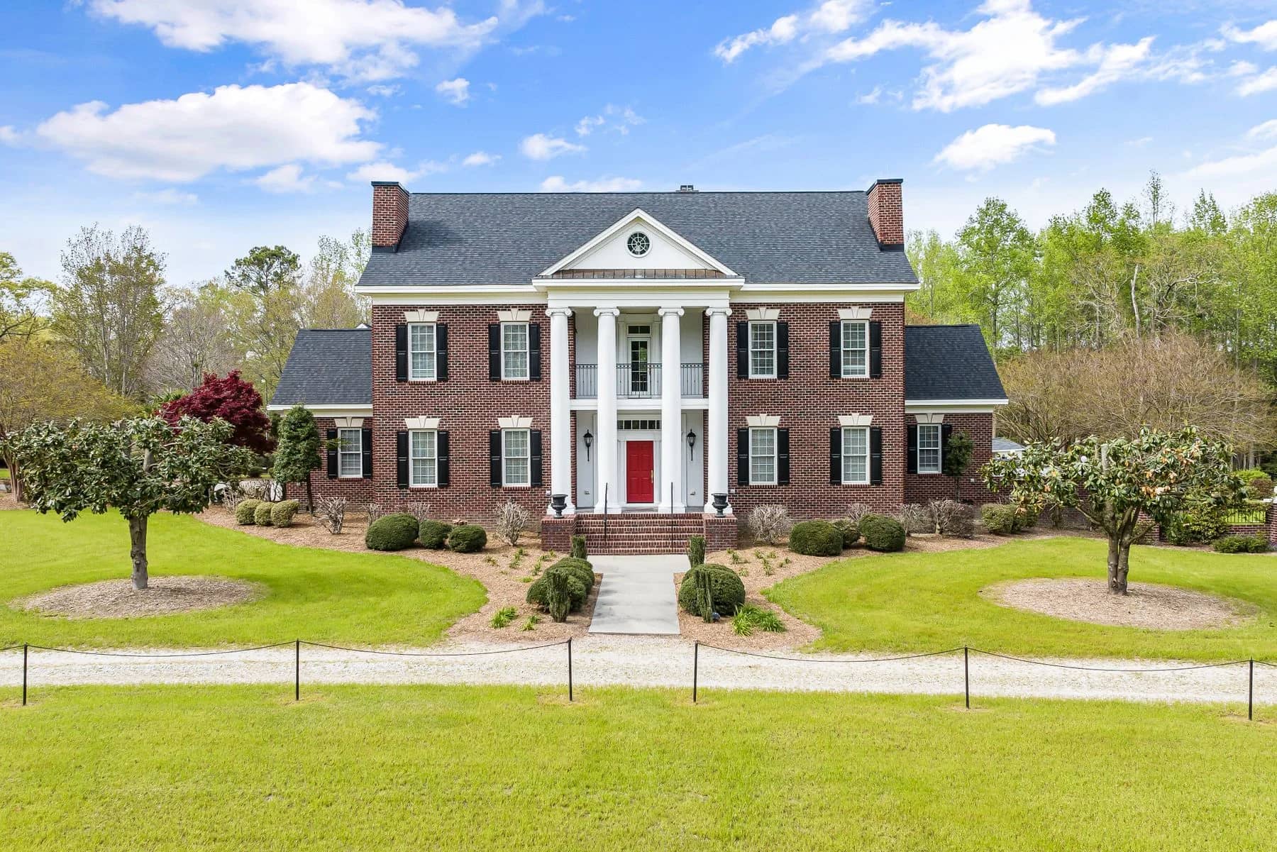 Brick Colonial estate with white columns and a tree-lined lawn — architectural inspiration
