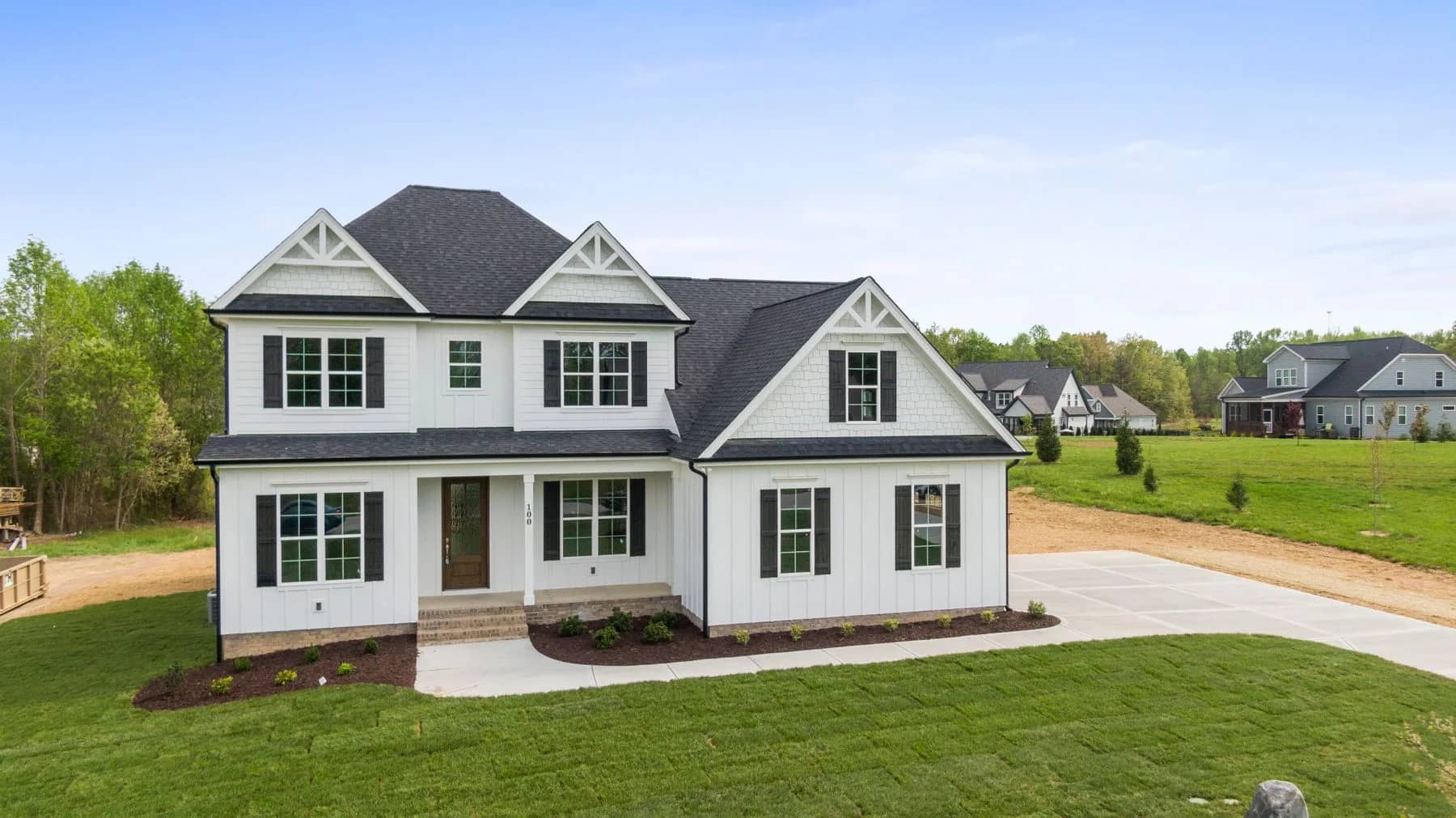 White gabled home with black shutters and a broad lawn — architectural inspiration