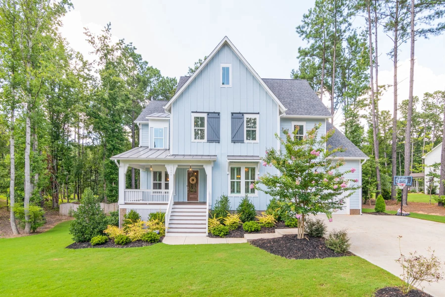 Blue gabled house with a front porch and mature trees — architectural inspiration