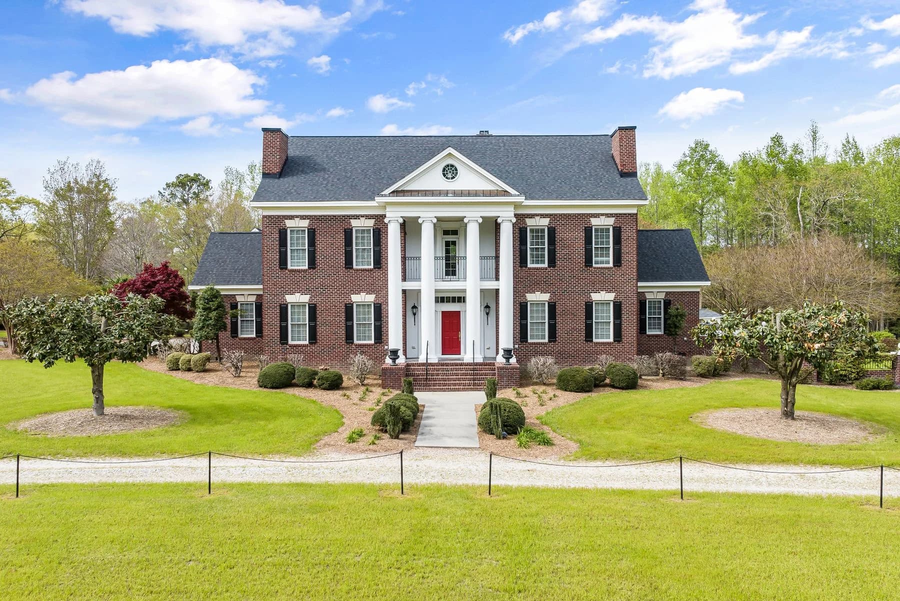 Brick Colonial estate with white columns and a tree-lined lawn — architectural inspiration