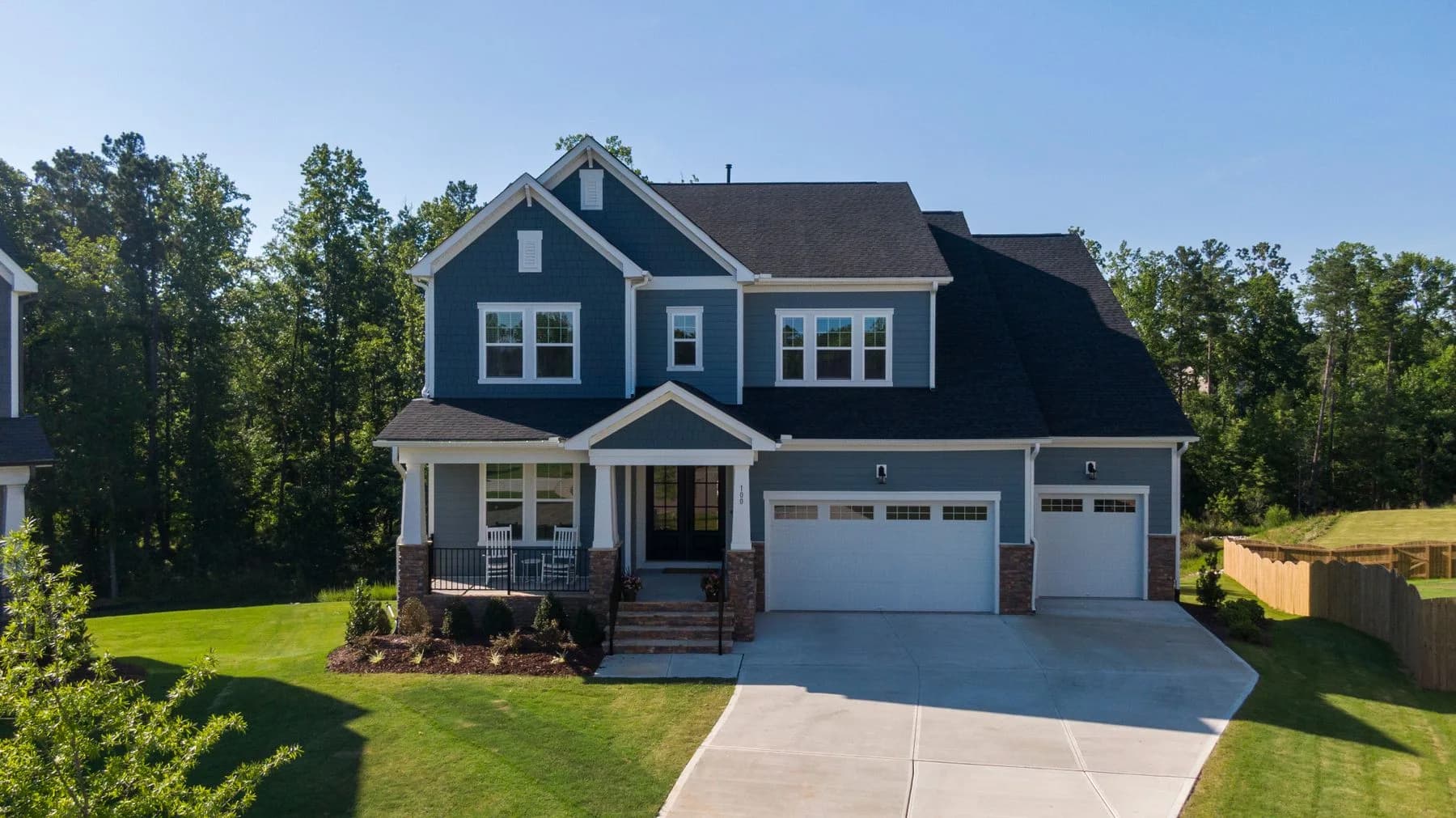 Blue-gray gabled home with a broad porch, lawn, and mature trees — architectural inspiration