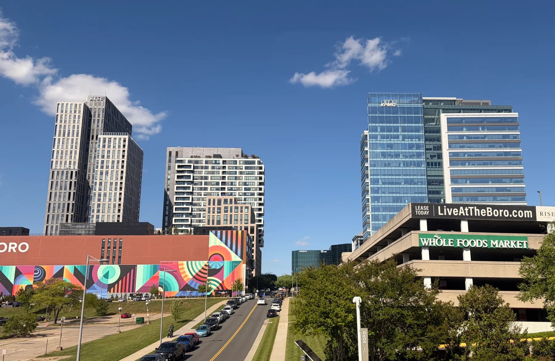 Colorful mural, storefronts, and residential towers along Silver Hill Drive at The Boro in Tysons