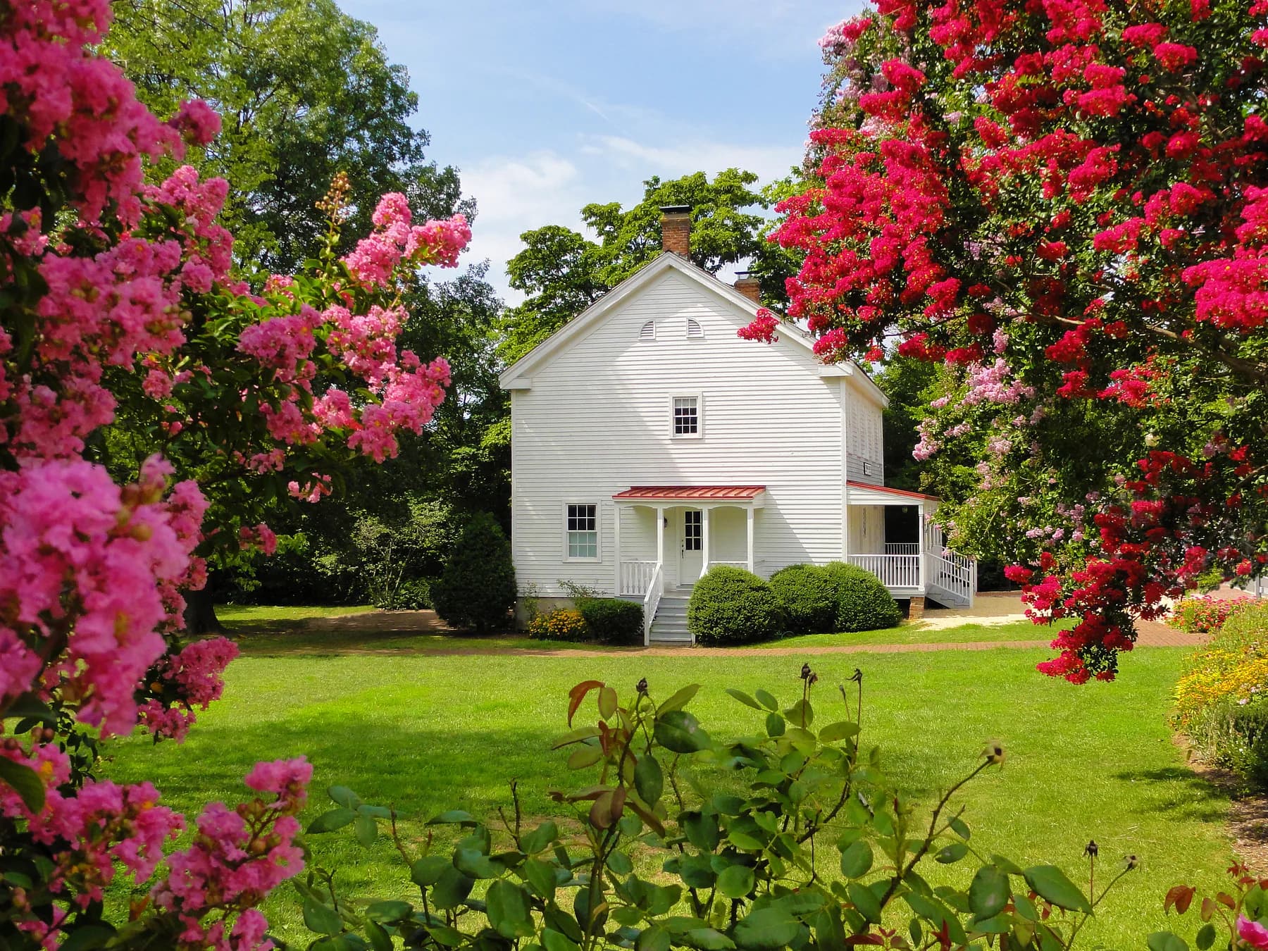 White Freeman House Store with a porch framed by flowering trees on Church Street in Vienna